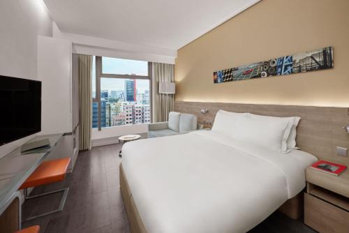 een groot wit bed in een hotelkamer met een raam bij Lodgewood by Nina Hospitality Mong Kok in Hong Kong
