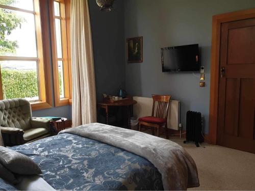 a bedroom with a bed and a tv on the wall at Belvedere Bed & Breakfast in Winton