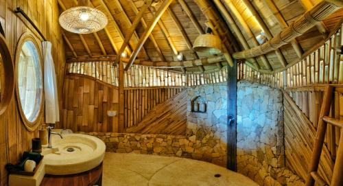 ein Bad mit einem Waschbecken und einem WC in einem Gebäude in der Unterkunft Kalma Bamboo Eco Lodge in Kuta Lombok