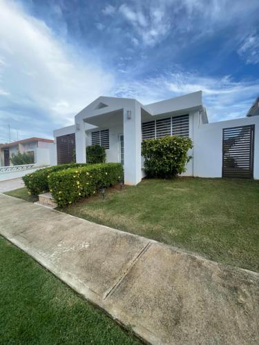 a white house with a green yard in front of it at akimekedo in Fajardo