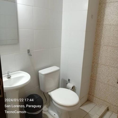ein Badezimmer mit einem weißen WC und einem Waschbecken in der Unterkunft Departamento en San Lorenzo in San Lorenzo