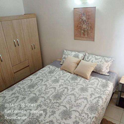 ein kleines Schlafzimmer mit einem Bett und einer Kommode in der Unterkunft Departamento en San Lorenzo in San Lorenzo
