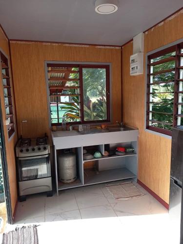 a kitchen with a sink and a stove at Natura Lodge Huahine in Puahua