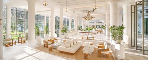 a lobby with white furniture and tables and windows at Centara Reserve Samui - SHA Plus in Chaweng