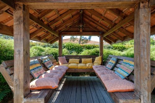 pérgola con almohadas y sillas en una terraza en Magnifique Villa Avec Jardin Proche De La Plage, en Arès