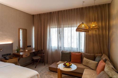 a hotel room with a couch and a bed at ERTH Abu Dhabi Hotel in Abu Dhabi