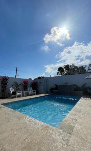 a swimming pool with chairs and a fence at akimekedo in Fajardo