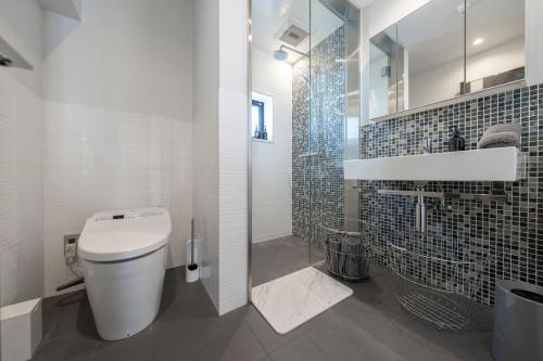 a bathroom with a toilet and a walk in shower at コートヤード広尾 in Tokyo