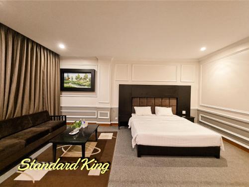 una camera d'albergo con letto e divano di MAY PLAZA HOTEL a Thái Nguyên