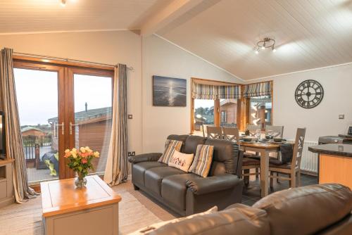 a living room with a couch and a table at 31 Ocean Terrace with Hot Tub Available to Hire in Woolacombe