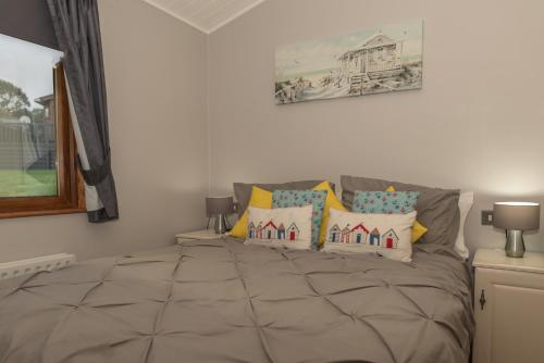 a bedroom with a large bed with colorful pillows at 31 Ocean Terrace with Hot Tub Available to Hire in Woolacombe