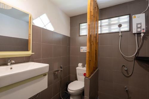La salle de bains est pourvue d'un lavabo, de toilettes et d'un miroir. dans l'établissement Lanta School Beach Resort, à Phra Ae beach
