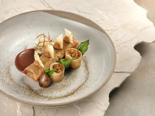 a plate of food with food on a table at Samsara Ubud in Ubud