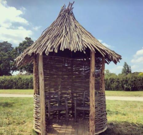 a straw hut with chairs in a field at Moksha glamping in Tetebatu