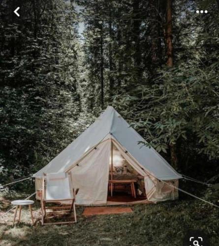 une tente blanche avec une chaise et une table dans l'établissement Moksha glamping, à Tetebatu