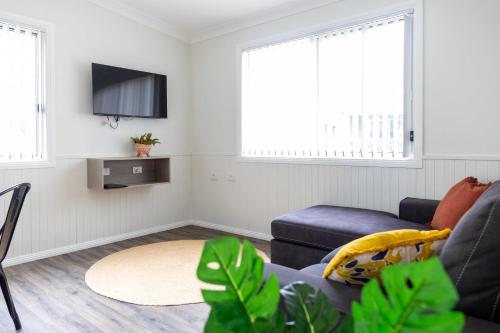 Una sala de estar con un sofá y un televisor. en Coonamble Riverside Caravan Park, en Coonamble