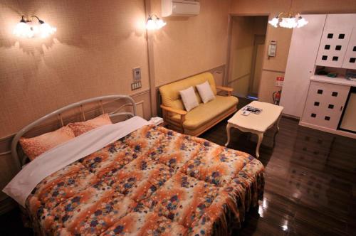 ein Krankenhauszimmer mit einem Bett und einem Stuhl in der Unterkunft パリセーヌ in Mitake