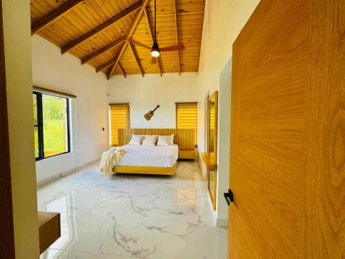 1 dormitorio con cama y techo de madera en The Grand Chalet en Jarabacoa
