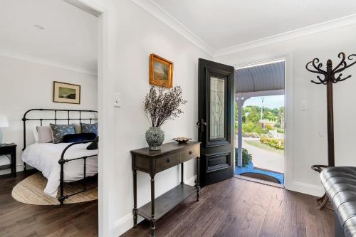 ein Schlafzimmer mit einem Bett und eine Tür mit einem Fenster in der Unterkunft Cherry Tree Cottage, Burrawang, Southern Highlands in Burrawang