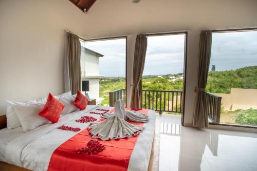 1 dormitorio con 1 cama grande con almohadas rojas en Jimbaran Sea View Villa, en Jimbaran