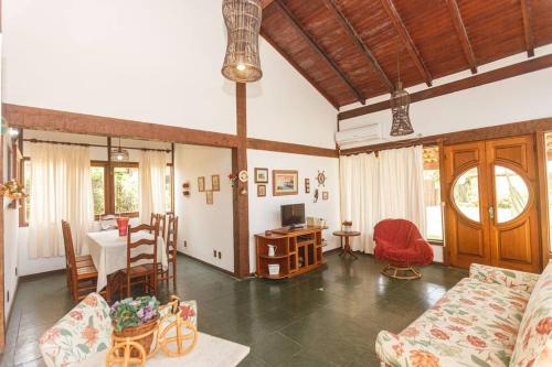 a living room with a couch and a table at Búzios casa em condomínio com cozinha completa e área gourmet in Búzios