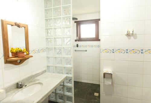 a bathroom with a sink and a shower at Búzios casa em condomínio com cozinha completa e área gourmet in Búzios