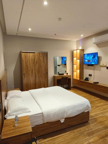 a bedroom with a large bed and a desk at قمة راحتي للشقق المخدومة Qimat Rahaity SERVICED APARTMENTS in Yanbu