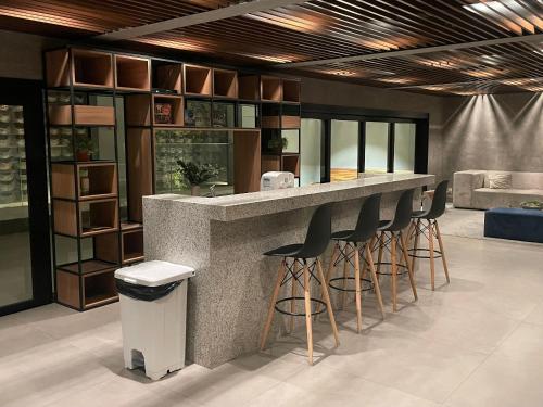 a kitchen with a counter with stools at a bar at Bexp Spaces | VN Capote Valente in São Paulo