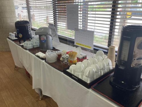 een lange tafel met kopjes erop bij Hotel Tetora Yunokawaonsen in Hakodate