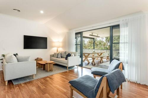 a living room with white furniture and a tv at Oceanview Luxury Retreat Amongst the Trees in Denmark