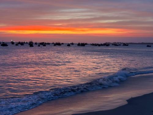 a beach with boats in the water at sunset at Barland Villa in Ke Ga
