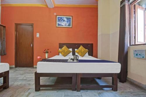 1 dormitorio con 1 cama grande y pared de color naranja en Stephels Hostel en Jaipur