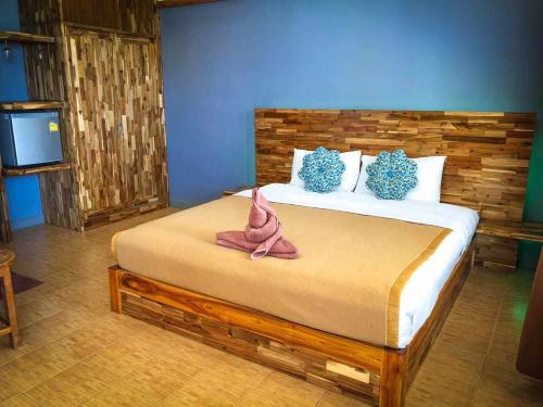 una camera da letto con un letto grande con testiera in legno di Lanta Ala Guest House a Phra Ae beach