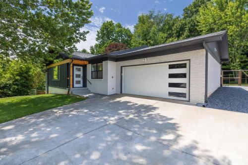 a house with a garage with a driveway at Mid-century Modern Impeccable Remodel with Hot Tub in Asheville