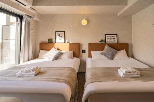 - 2 lits dans une chambre avec fenêtre dans l'établissement Apartment Hotel 11 Kuromon II, à Osaka