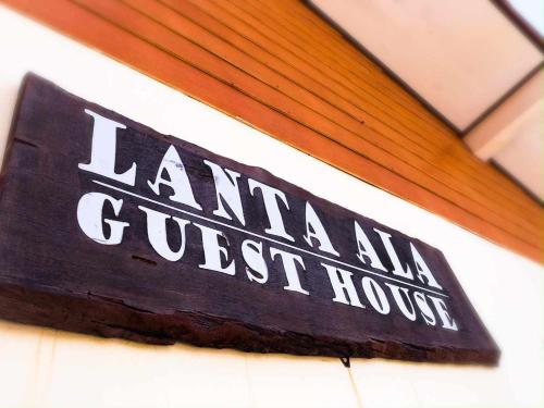 un cartello sul lato di un edificio di Lanta Ala Guest House a Phra Ae beach