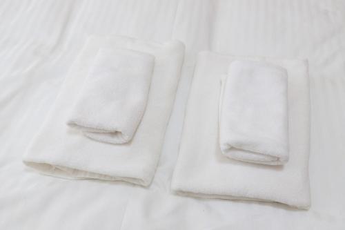 dos toallas blancas sentadas sobre una mesa en Rooms平尾 en Fukuoka