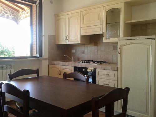 a kitchen with a wooden table and a dining room at Il Giardino dei Ciliegi in Cura Nuova