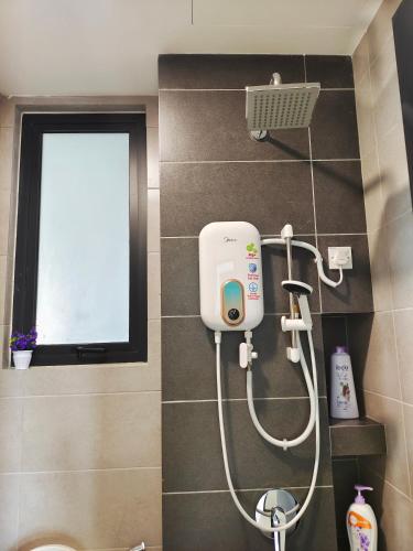 La salle de bains est pourvue d'une douche et d'une fenêtre. dans l'établissement Luxury Comfort Suite 3BR, à Jelutong