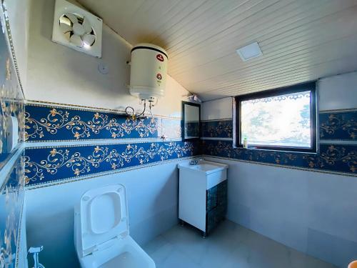a small bathroom with a toilet and a window at Rudhraksh Villa 4BR- Perfect Vacay Villa in Mussoorie