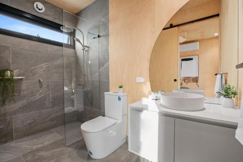 a bathroom with a toilet and a sink and a shower at Tasman Holiday Parks - St Helens in St Helens