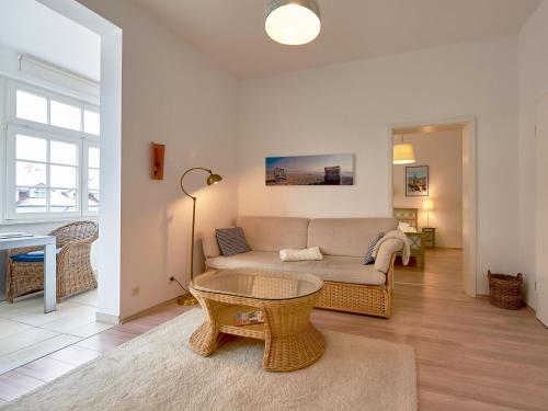 - un salon avec un canapé et une table dans l'établissement Haus Metropol in Binz - Wohnung 9, à Binz