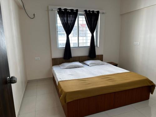 sypialnia z łóżkiem i oknem z zasłonami w obiekcie Blissful stays w mieście Pune