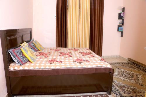 a bed with pillows on it in a room at Choudhary Mansion in Rāmnagar
