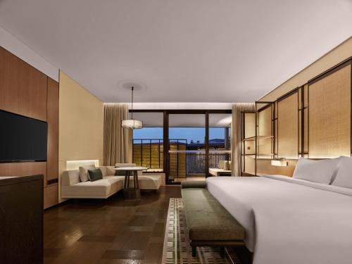 a hotel room with a bed and a living room at Banyan Tree Dongguan Songshan Lake in Dongguan