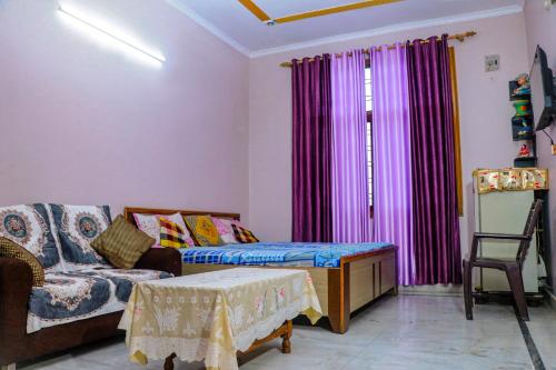 a living room with a couch and purple curtains at Choudhary Mansion in Rāmnagar