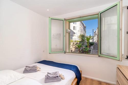 une chambre avec deux lits et une grande fenêtre dans l'établissement Cannes 3 pièces Rénové 2023 Vieux Port et Palais Olam Properties, à Cannes