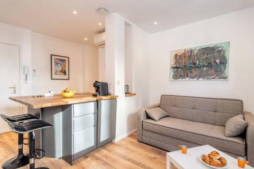 un salon avec un canapé et une table dans l'établissement Cannes 3 pièces Rénové 2023 Vieux Port et Palais Olam Properties, à Cannes