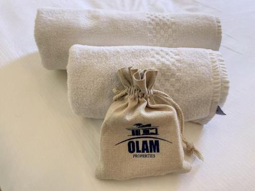 une pile de serviettes et un sac sur une table dans l'établissement Cannes 3 pièces Rénové 2023 Vieux Port et Palais Olam Properties, à Cannes