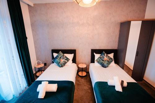 two beds in a room with two crosses on them at Complex Omnia - Apartamente Husi in Huşi
